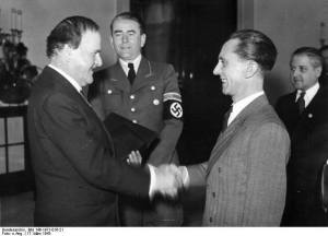 Wilhelm Kreis (z lewej, w marynarce) przyjmuje z rąk Goebbelsa nominację na generalnego radcę budowlanego niemieckich cmentarzy wojennych. Przy nim (w mundurze) Albert Speer.